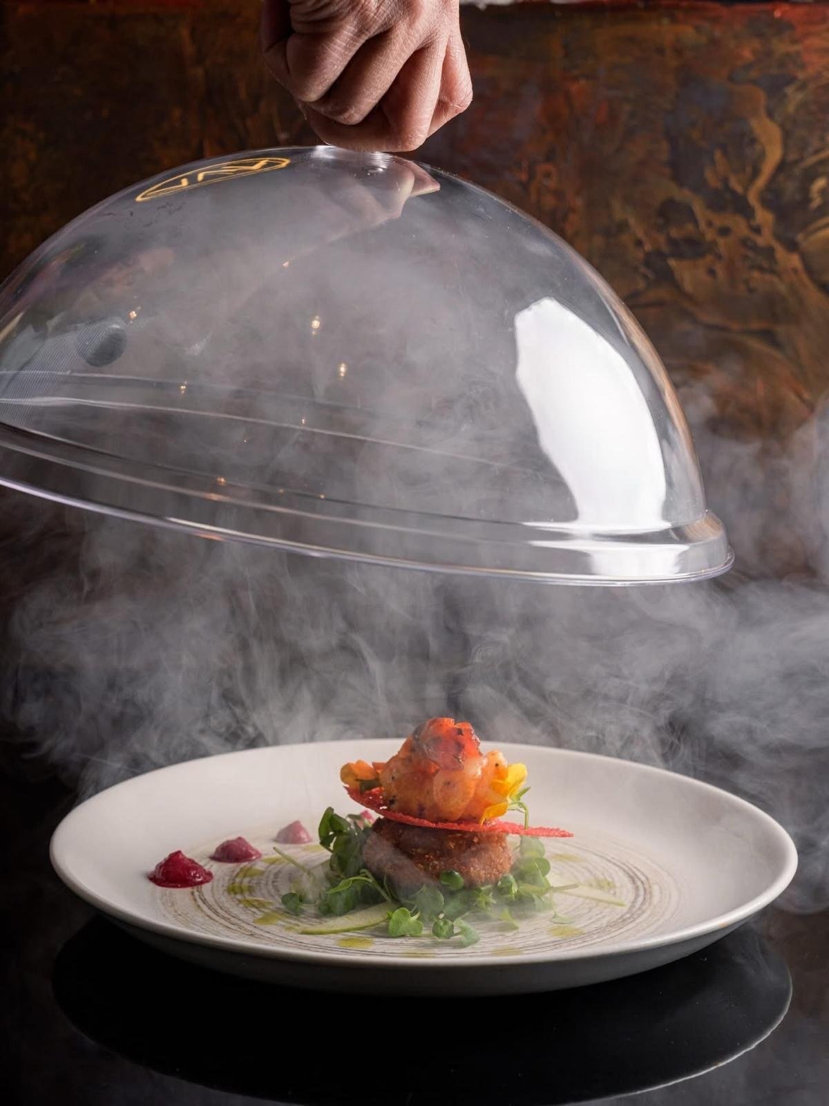 A dish finished under a smoking glass dome