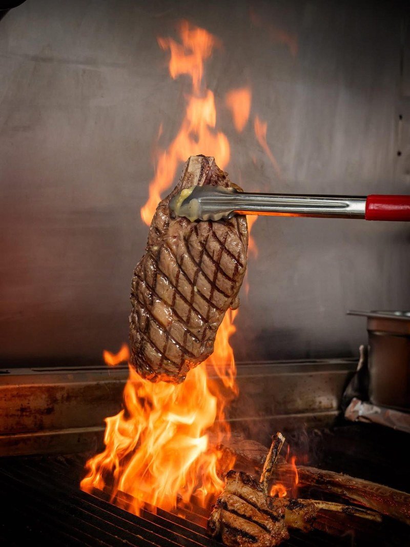 Steak lifted off the open grill