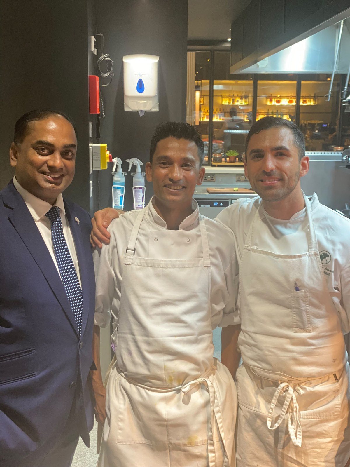Chef Rasel in whites with two colleagues in a hotel kitchen